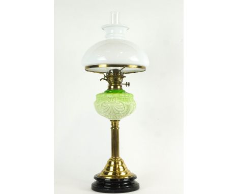 A 19th century brass oil lamp, the opaque glass shade above a pierced burner, stamped 'British made', above a green tinted op