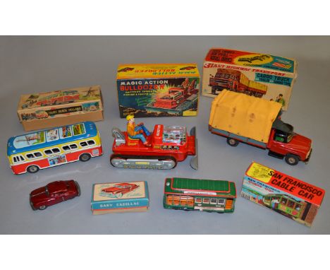 A mixed group of boxed tinplate battery operated and friction powered toys including a 'Magic Action Bulldozer'  appears VG w