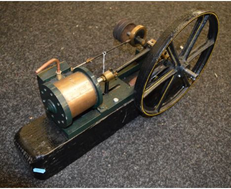 Large model of a Horizontal steam engine of cast iron and brass construction with 12" flywheel. Rough wooden plinth base is 5