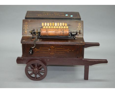 The Gem Roller Organ. Wooden musical organ on on wheeled stand, plays tune when wound and bellows are pressed, length 54cm, t