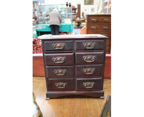 AN EARLY 20TH CENTURY MAHOGANY TABLE TOP CHEST of eight drawers with copper handles and raised on bracket feet 35cm wide