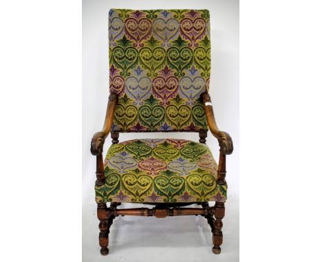 AN EARLY 20TH CENTURY MAHOGANY FRAMED HIGH BACK ARMCHAIR with a tapestry upholstered back and seat, scrolling arms and turned