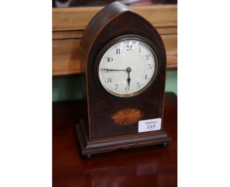 AN EDWARDIAN MAHOGANY AND BOX STRUNG MANTEL TIMEPIECE of plain arched form, having enamel dial, the case inlaid with an oval 