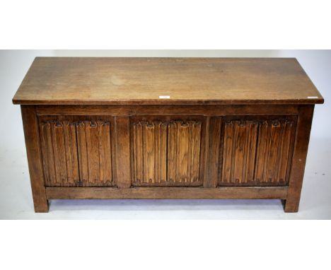 AN OAK COFFER with linen fold carved triple panel front, 114cm