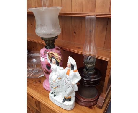 A LATE VICTORIAN BRITISH MADE PINK GLASS OIL LAMP 40cm high, a further Victorian oil lamp, a Staffordshire flat back figurine