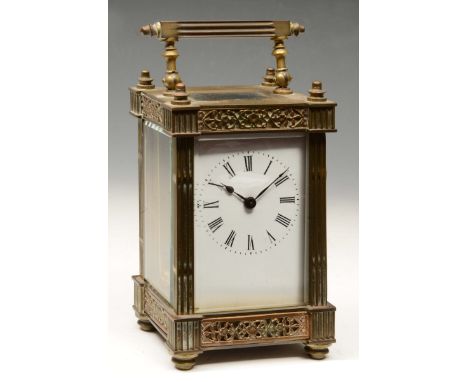 A LATE 19TH CENTURY FRENCH BRASS CARRIAGE TIMEPIECE with white enamel dial, the case with pierced foliate copper toned frieze