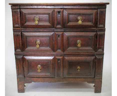 AN ANTIQUE OAK CHEST of three moulded drawers with brass drop handles and standing on bracket feet 85cm wide 