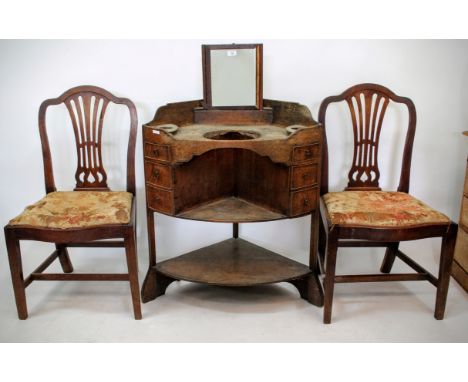 A 19TH CENTURY OAK CORNER WASHSTAND with rising mirror to the back, fitted with three small drawers and two open shelves, 74c