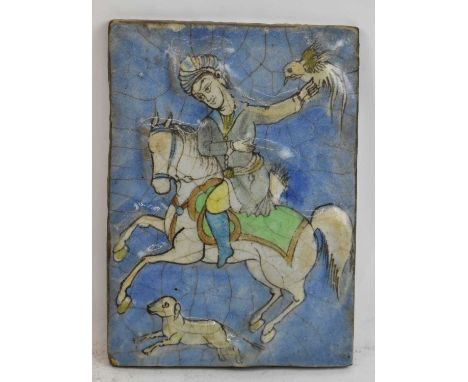 An 18th/19th century Persian rectangular tile decorated with a figure riding a horse, 25 x 18.5cm. 