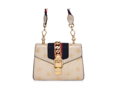 A GUCCI MINI SYLVIE BEE STAR HANDBAG
Gold-tone hardware, clasp chain and buckle front flap closure, one detachable rope shoul