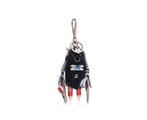 A PRADA RUFUS FUR KEYCHAIN
Black shearling fur with metal parts. including crocodile clip hands on wires and iron cord arms, 