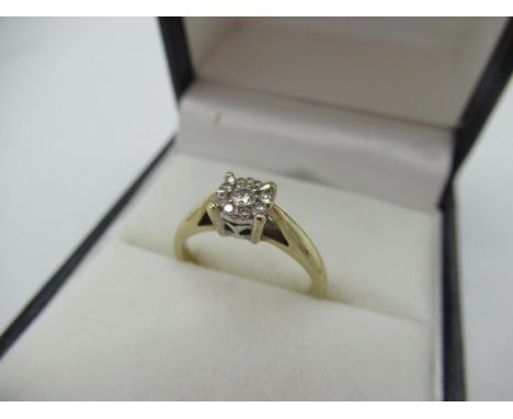 Hallmarked 9ct yellow gold diamond ring with a central round cut diamond and a halo of eight smaller round cut diamonds inset