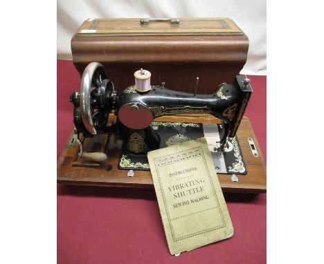 Cased vintage vibrating shuttle sewing machine, hand operated, instruction book and trade label for J H Swift of Scarborough 