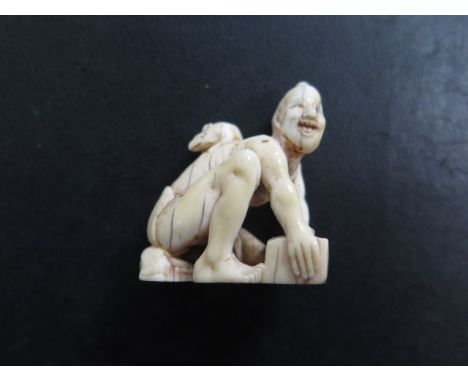 A well carved antique Japanese Meiji netsuke of a seated man with a rat on his back, 3.5cm x 3cm, some age related cracks but