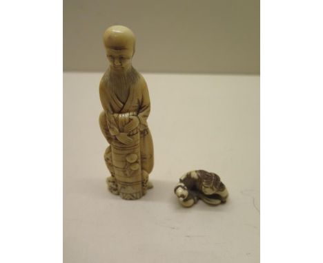 A 19th century Japanese carved ivory figure, 11cm tall, chips to foot and some age related cracks, also with a netsuke of a s