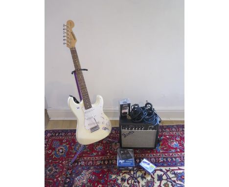 A Fender Starcaster 6 string Strat electric guitar with a Fender Frontman 15G amp and assorted attachments and stand 