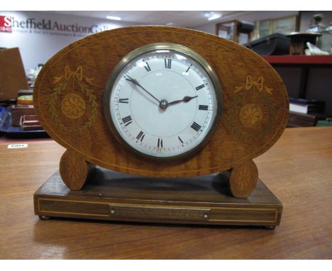 An Early XX Century Oak Oval Cased Mantel Clock, with ribbon inlay, on rectangular presentation base, black Roman numerals to