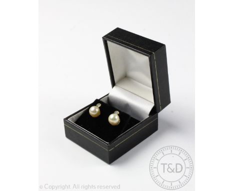 A pair of pearl and emerald set stud earrings, designed as an emerald stud, collet set above a pearl drop, all set in 9ct yel