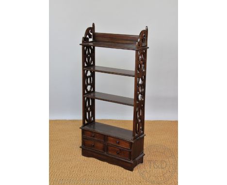 A Regency style mahogany dwarf open bookcase, with four shelves with pierced sides and four short drawers, on bracket feet, 1