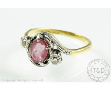 A pink sapphire and diamond three stone cross-over ring, the central oval sapphire within four claw setting and with illusion