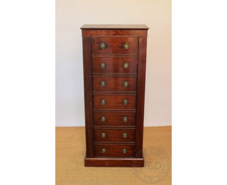 A gun cabinet modelled as a Regency Wellington chest, with locking bar and door with two locks seven faux drawers enclosing a