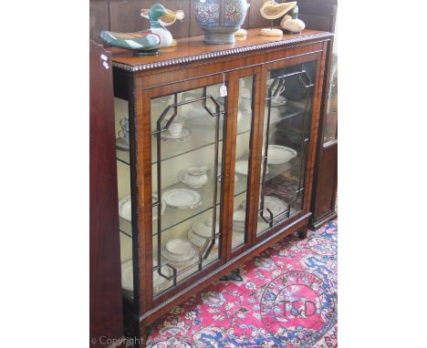 A 1920's walnut display cabinet, with two astragal glazed doors, on bracket feet, 123.5cm H x 137cm W x 35.5cm D