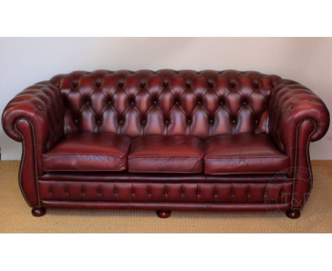 A red leatherette three seater Chesterfield settee, with button back upholstery, 200cm 