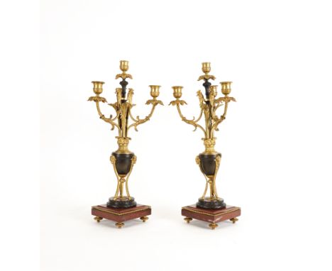 A PAIR OF LOUIS XVI STYLE GILT AND PATINATED METAL MOUNTED FOUR LIGHT CANDELABRA (2)20th Century  Each with writhen scroll ac