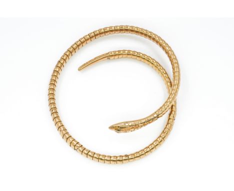 A GOLD BANGLEDesigned as a sprung coiled serpent, with green gem set eyes, detailed 9 CT, gross weight 15.6 gmsCondition repo