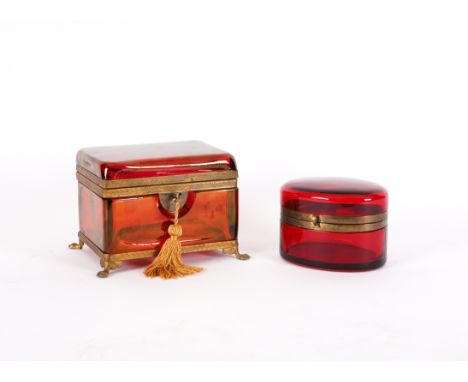 A FRENCH OR BOHEMIAN RUBY TINTED GLASS AND GILT-METAL MOUNTED CASKET AND AN OVAL EXAMPLE (2)Late 19th / Early 20th Century  T