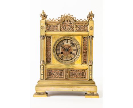 A FRENCH BRASS MANTEL CLOCKLate 19th century The rectangular case with foliate finials and arched centre, the front inset wit