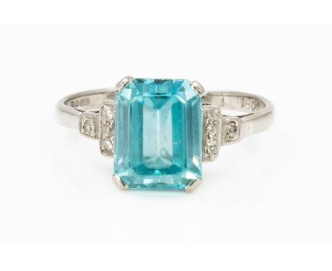 AN 18CT WHITE GOLD, BLUE ZIRCON AND DIAMOND RINGClaw set with the emerald cut blue zircon at the centre, between diamond thre