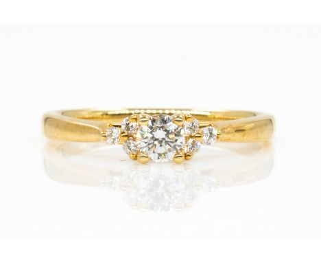 AN 18CT GOLD AND DIAMOND RINGClaw set with the principal circular cut diamond between circular cut diamond set three stone sh