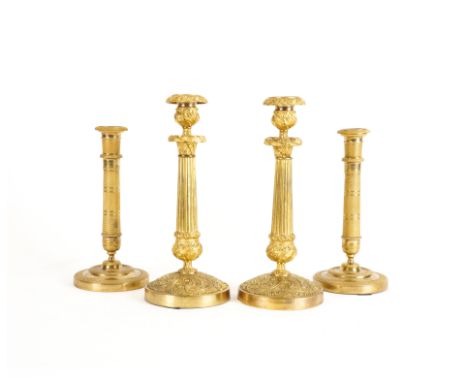A PAIR OF EMPIRE GILT-BRASS ENGINE MILLED CANDLESTICKS (4)19th Century  The columnar shafts composed of bands of rosettes, be