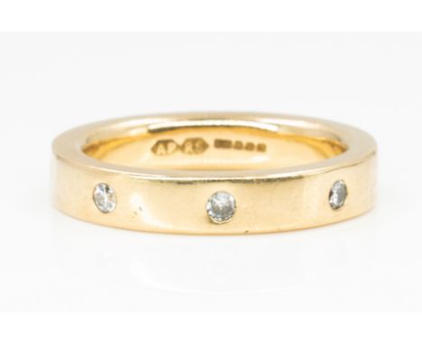 AN 18CT GOLD AND DIAMOND BAND RINGMounted with circular cut diamonds, ring size M and a half, gross weight 7.5 gms