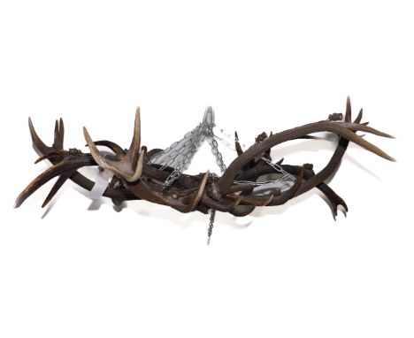 AN ANTLER HORN SIXTEEN LIGHT CHANDELIER OR HANGING LIGHTEarly 20th Century  Composed of eight pairs of antlers, each antler m