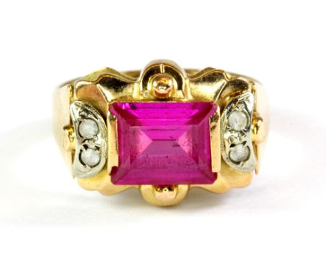 An 18ct yellow gold (stamped 750) ring set with a baguette cut ruby and white spinel, (Q).