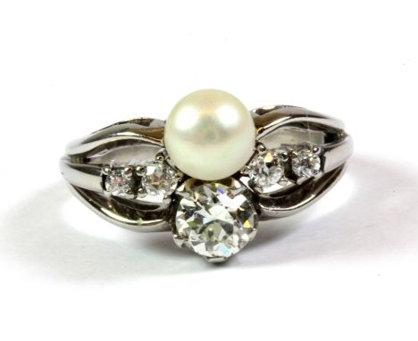 A white metal (tested 14ct white gold) diamond and pearl set "bypass" ring, c. 1941, in an antique ring box, (approx. 1ct dia