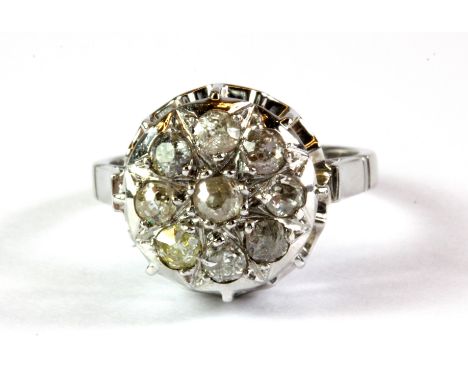 A white metal (tested 18ct gold) cluster ring set with old cut diamonds, (K).
