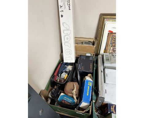 A group of photography equipment, including vintage Praktica MTL3 camera, Panasonic Lumix digital camera, various accessories