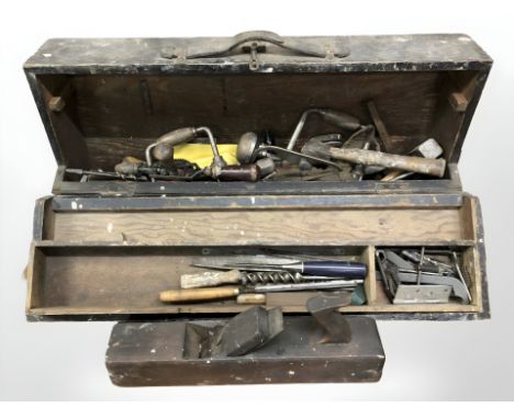 An antique joiners toolbox containing assorted carpentry tools, hand drills, hammers, chisels, woodworking plane, etc. 