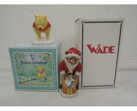 Two ceramic figurines a Royal Doulton Pooh bear and Wade Father Christmas catkins