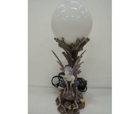 A novelty table top lamp in the form of a woodland fairy under moon