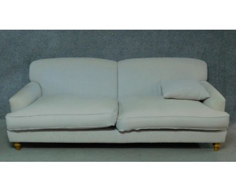 A contemporary two seater sofa in cream upholstery. H.80 W.220 D.115cm 