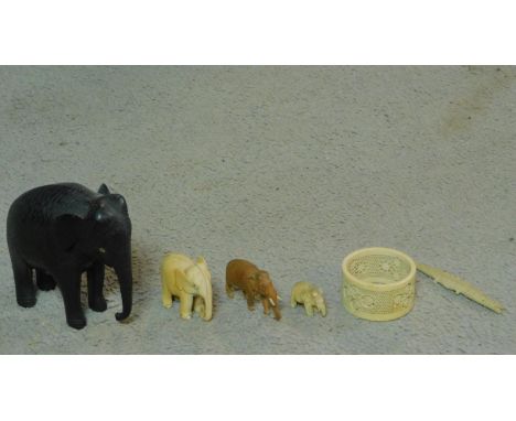 A collection of antique ivory and carved items. Including an ebony elephant with carved detaling, a bone crocodile, a wooden 