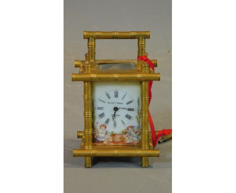 An antique gilt carriage clock, with enamel painted panels with cherubs catching butterflies. White enamel dial with Roman nu