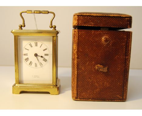 LATE 19TH/EARLY 20THC BRASS CARRIAGE CLOCK BY E. DOBELL OF HASTINGS WITH KEY IN A LEATHER CASE. 11CM HIGH.