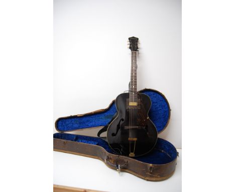 A VINTAGE GIBSON CROMWELL 6 STRING ELECTRIC ACOUSTIC GUITAR WITH F SHAPED SOUND HOLES, BRASS MOUNTS AND PICKUP. MADE IN THE U