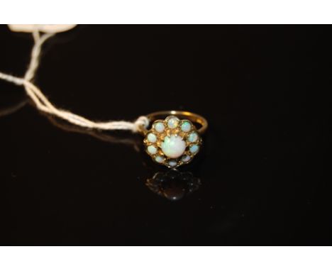 9CT GOLD RING WITH LARGE CENTRE OPAL SURROUNDED BY 10 SMALLER OPALS CIRCA 20THC (40.2 GR GROSS).