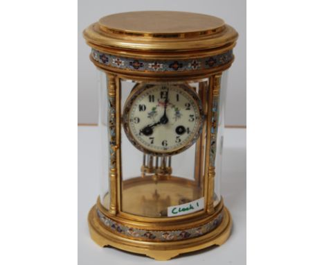 EARLY 20THC FRENCH OVAL GILT & CHAMPLEVÉ ENAMEL CLOCK WITH 4 PANELS OF BEVELLED GLASS & HAND PAINTED FLORAL GARLAND ON THE DI
